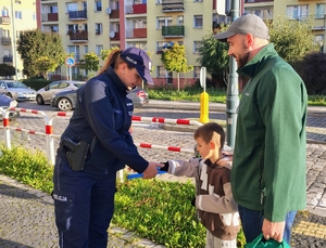 policjantka przekazuje odblaski uczniom