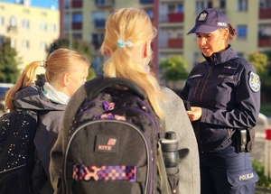 policjantka przekazuje odblaski uczniom