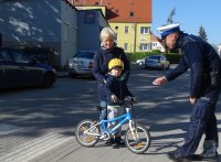 Policjanci rozdają dzieciom i rodzicom odblaski i odznaki &quot;Jestem bezpieczny – jeżdżę w foteliku&quot;