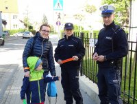 Policjanci rozdają dzieciom i rodzicom odblaski i odznaki &quot;Jestem bezpieczny – jeżdżę w foteliku&quot;