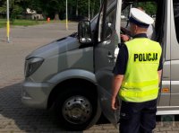 Policjanci z ruchu drogowego kontrolują autokar przed wyjazdem na wycieczkę z dziećmi