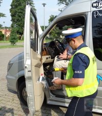 Policjanci z ruchu drogowego kontrolują autokar przed wyjazdem na wycieczkę z dziećmi