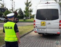 Policjanci z ruchu drogowego kontrolują autokar przed wyjazdem na wycieczkę z dziećmi