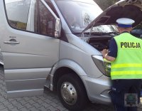 Policjant z ruchu drogowego kontroluje autokar przed wyjazdem na wycieczkę z dziećmi