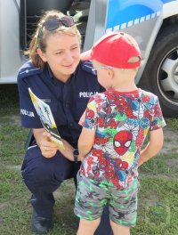 policjantka przekazuje książeczkę &quot;Bezpieczny Przedszkolak&quot;