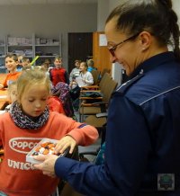 policjantka częstuje dzieci słodyczami