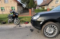 policjanci pracują na miejscu zdarzenia drogowego w którym brał udział motocykl i samochód osobowy