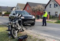 policjanci pracują na miejscu zdarzenia drogowego w którym brał udział motocykl i samochód osobowy