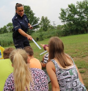 policjantka rozdaje dzieciom opaski odblaskowe